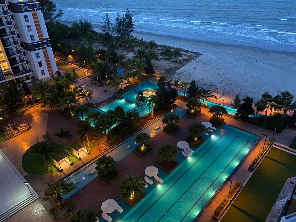关丹Eyu@Timurbay Seaview Residence的享有游泳池和海滩的顶部景色。