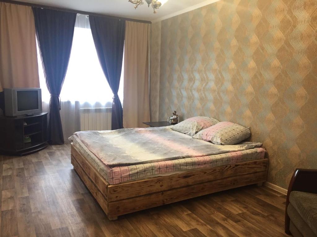 基辅Apartment on the Obolon的一间卧室配有一张木框床和窗户。