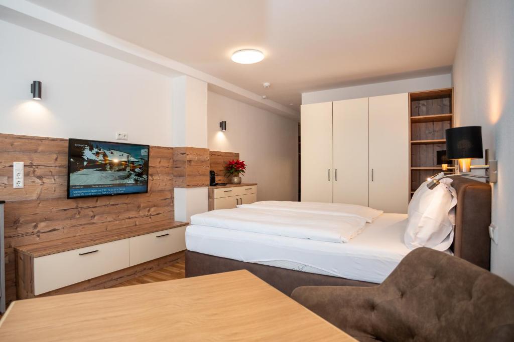 滨湖采尔Appartementhaus AURUM的一间卧室配有一张床,墙上配有电视