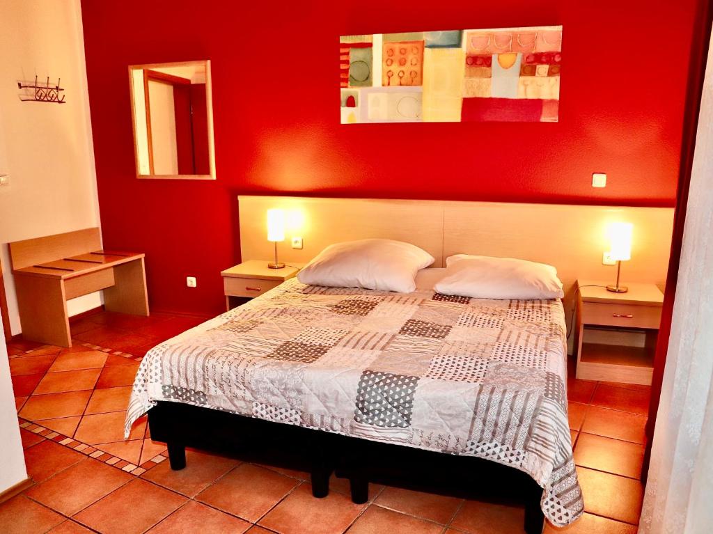 美因河畔法兰克福Hotel Aurelia的红色卧室,配有带2个床头柜的床