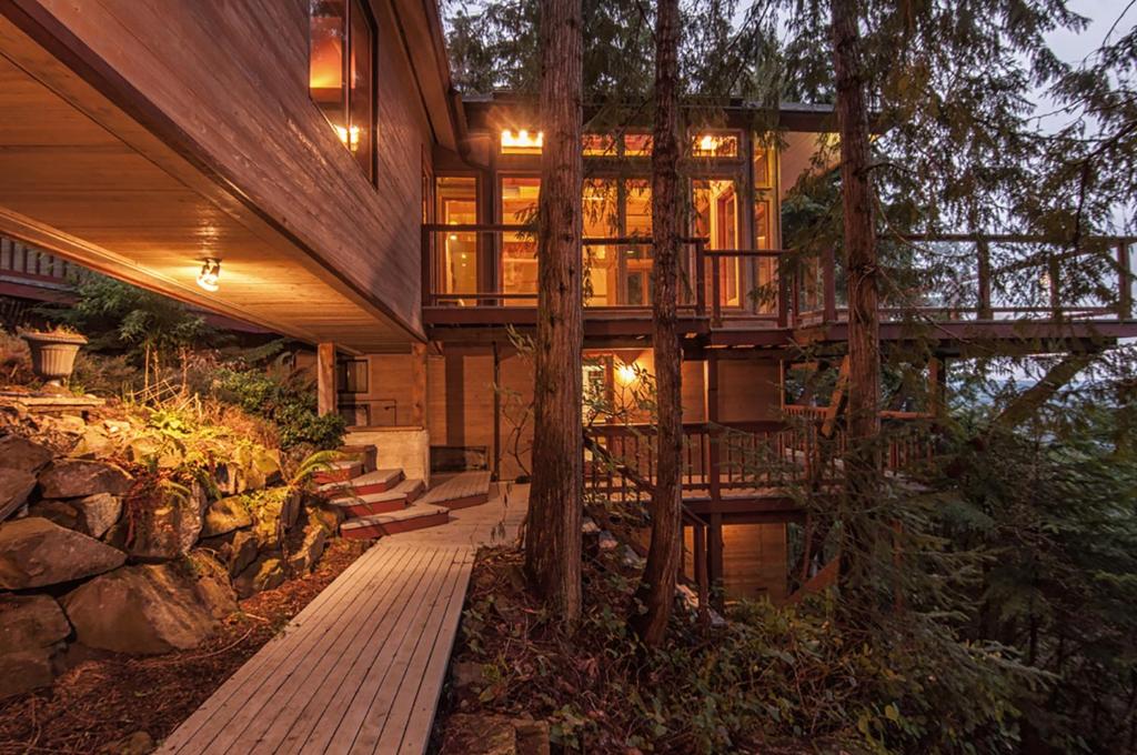Salt Spring IslandThe Sanctuary Retreat & Spa的树林中的房屋,有甲板和树木