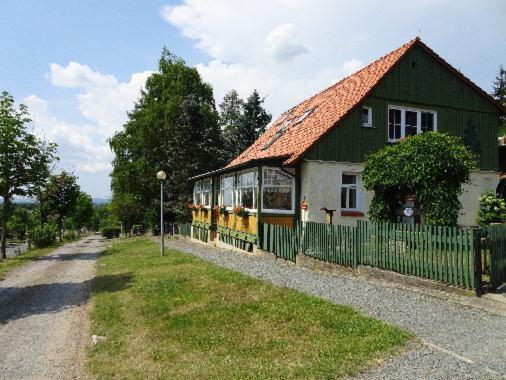 弗雷德里希斯布鲁恩Ferienwohnungen Weber的绿色和黄色的小房子,带围栏