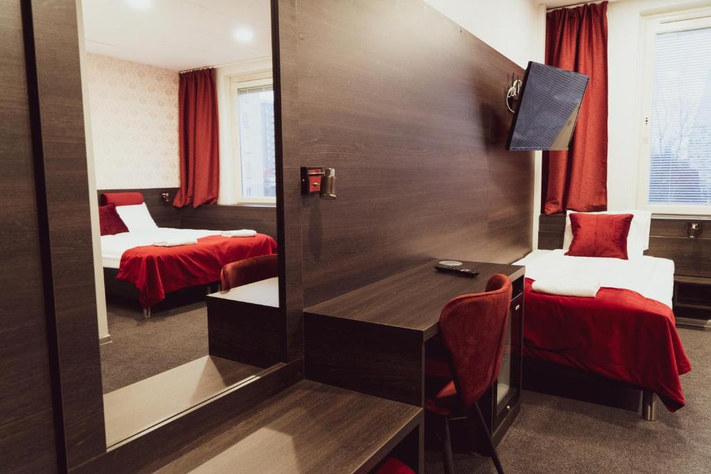 斯德哥尔摩利耶赫门斯施塔特斯酒店的客房设有两张床、一张桌子和一面镜子。
