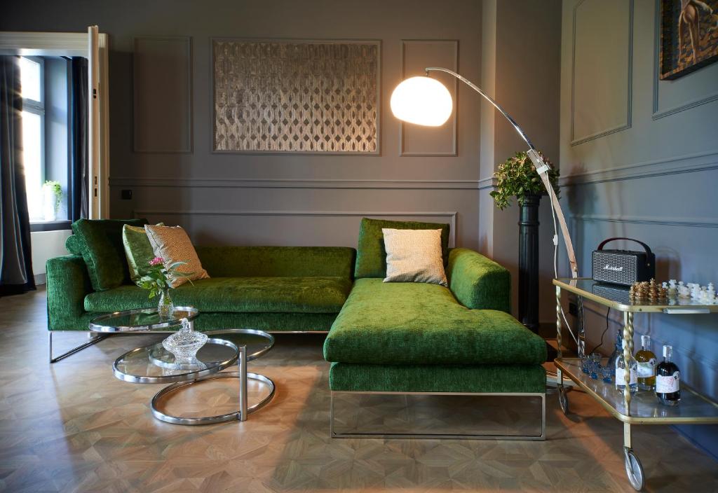 莱比锡Cora Apartments的客厅配有两张绿色沙发和桌子