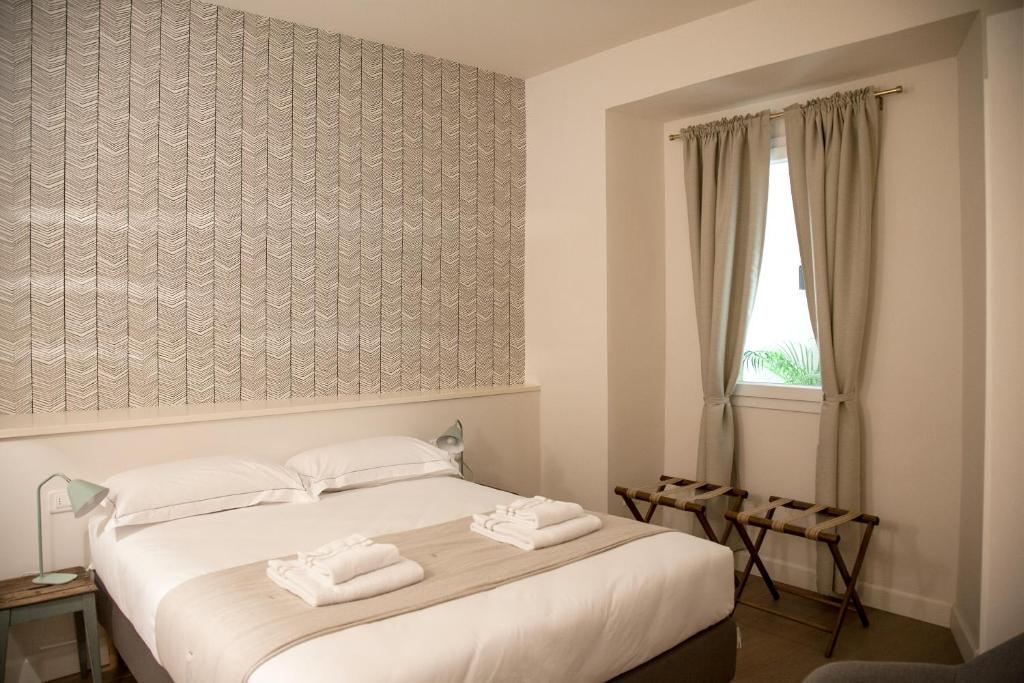 佛罗伦萨Pietrapiana Boutique Apartments的一间卧室配有一张床,上面有两条毛巾