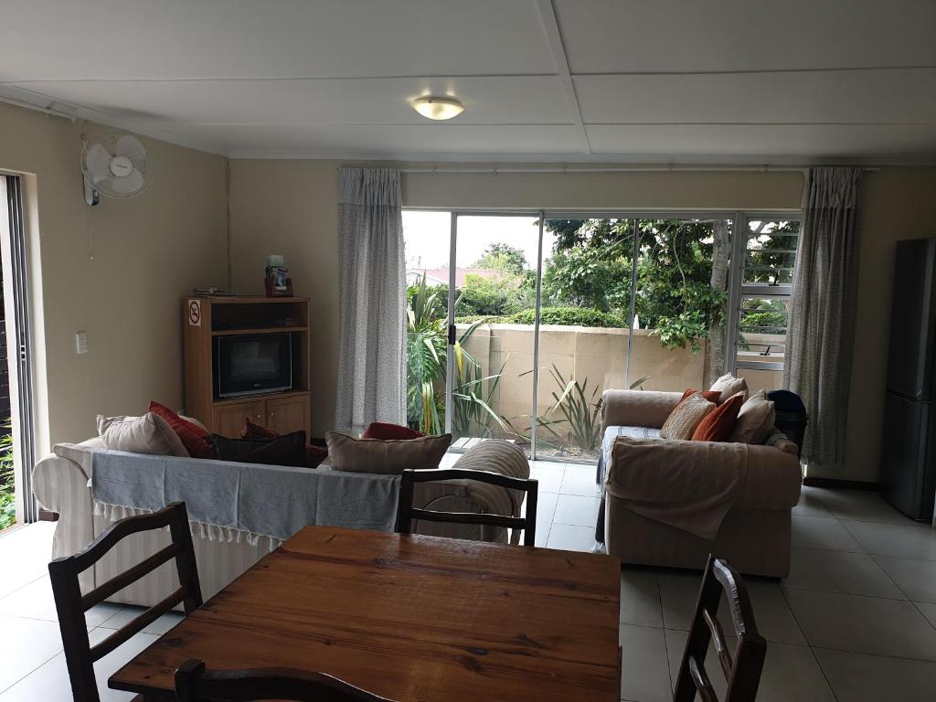 普利登堡湾Amakaya Backpackers Travellers Accommodation的客厅配有沙发、椅子和桌子