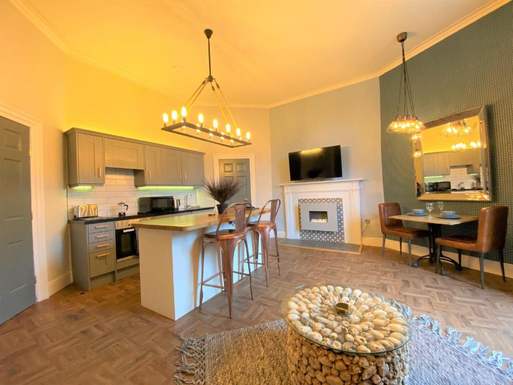 利兹利明克莱蒙特公寓的厨房以及带桌椅的起居室。