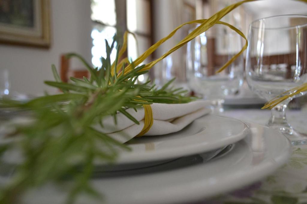 阿斯蒂拉洛坎达迪维尔贝拉农家乐的一张桌子,上面有植物,上面有白色的盘子
