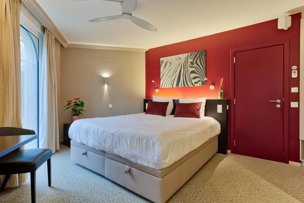 根特根特阿斯托利亚酒店的红色的卧室,配有一张床和红色的墙壁