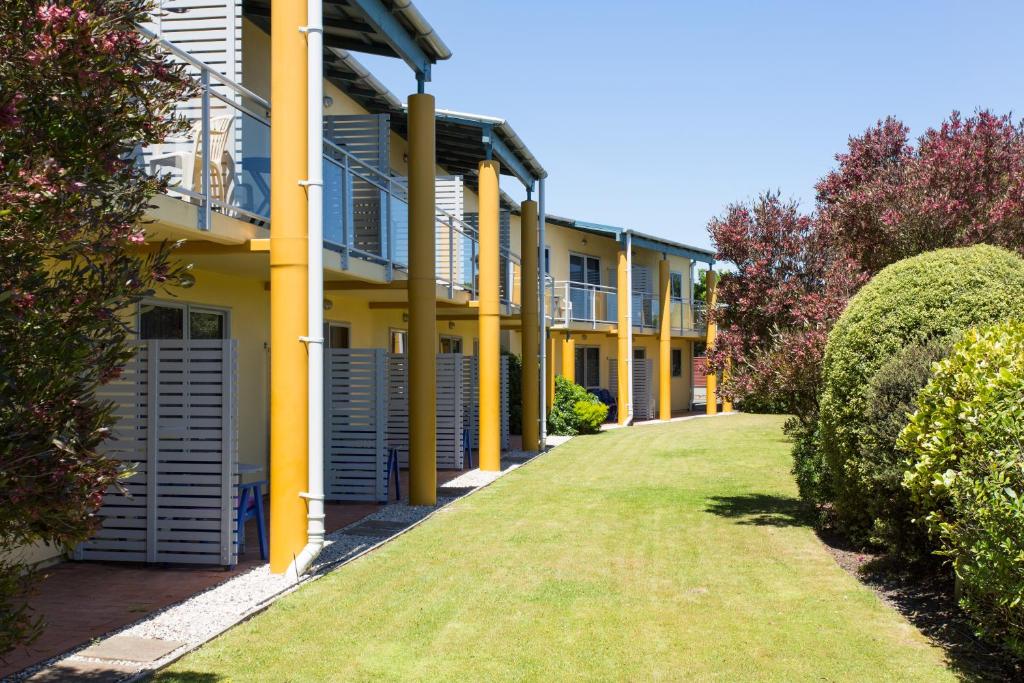 纳尔逊格林斯汽车旅馆的一排有黄色柱子和草的房屋