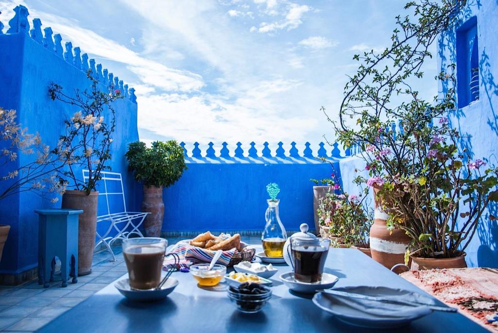 舍夫沙万Casa Perleta的天井上的蓝色桌子,上面摆放着食物和饮料