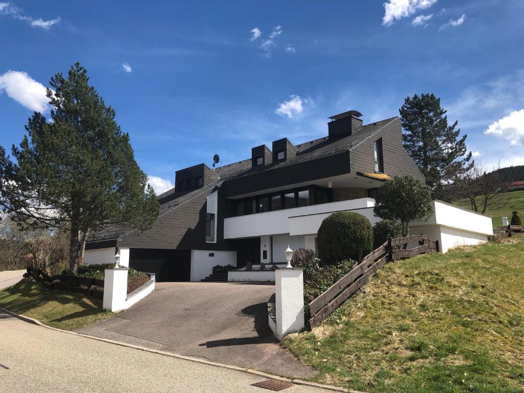拜尔斯布龙Luxus-Landhaus im Schwarzwald/Baiersbronn mit Pool的山丘上带车道的房子