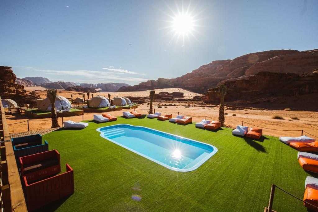 瓦迪拉姆Palmera Camp Wadi Rum的草地上游泳池的 ⁇ 染