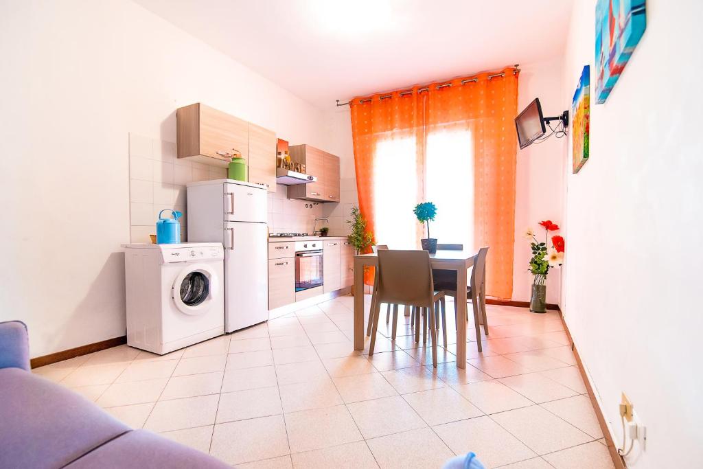 利多迪耶索罗Residence Comfort的厨房配有桌子、冰箱和洗衣机。