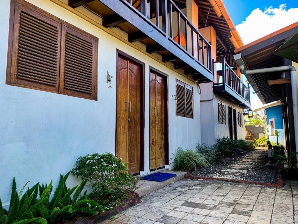 金巴兰Capung Guesthouse的白色的建筑,设有木门和走道