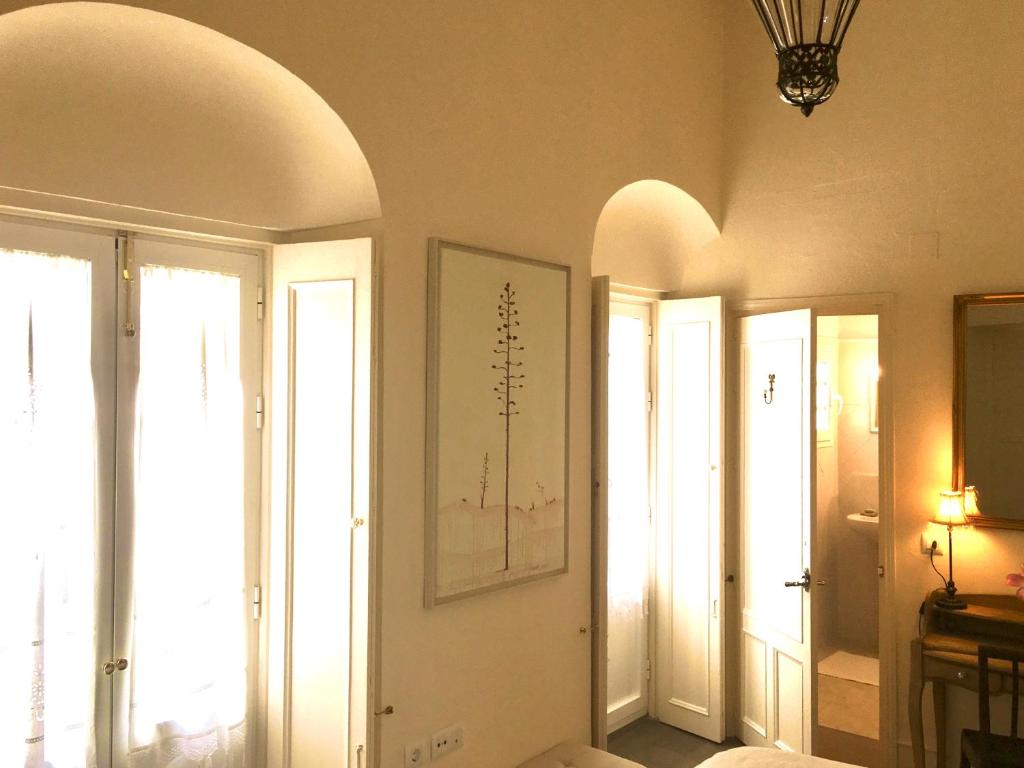 麦地那西多尼亚Número 9的一间设有白色门窗和吊灯的客房