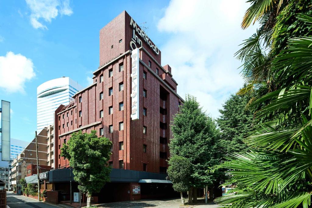 埼玉市Marroad inn omiya的一座高大的红砖建筑,上面有标志