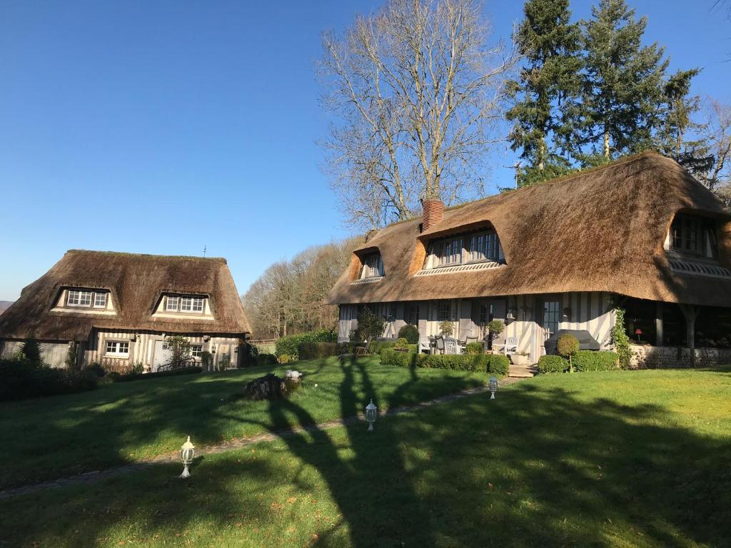 Le Breuil-en-Auge低谷乡村民宿的两栋茅草小屋,位于绿树成荫的草坪上