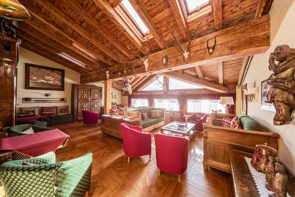 布勒伊-切尔维尼亚朱梅奥克斯酒店的大型客厅设有木制天花板和红色椅子