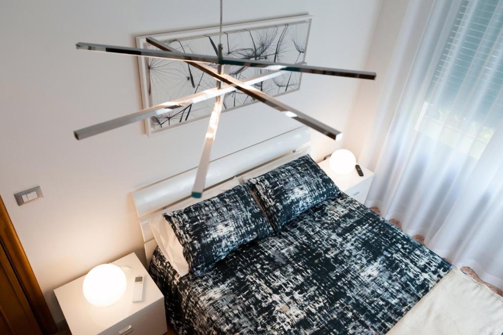 佩斯卡拉Fly by Suites Pescara的一间卧室配有一张带吊灯的床。