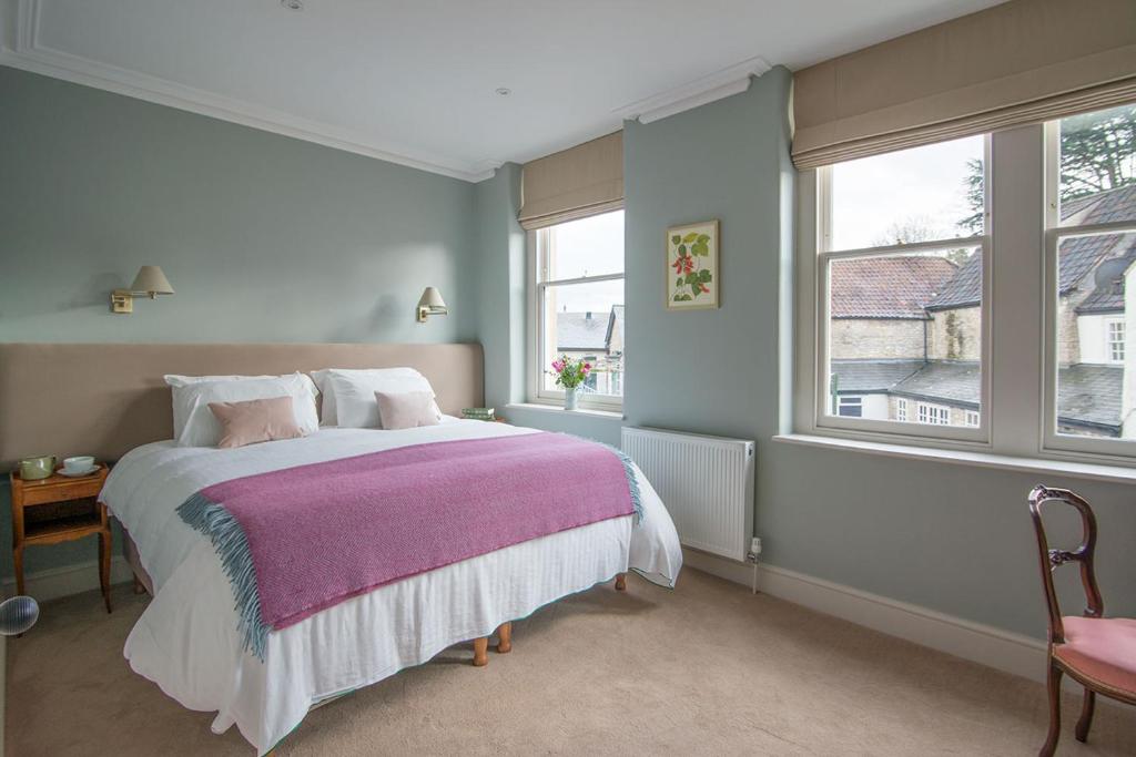 弗罗姆Bistro Lotte的一间卧室配有一张带紫色毯子的床和两个窗户。