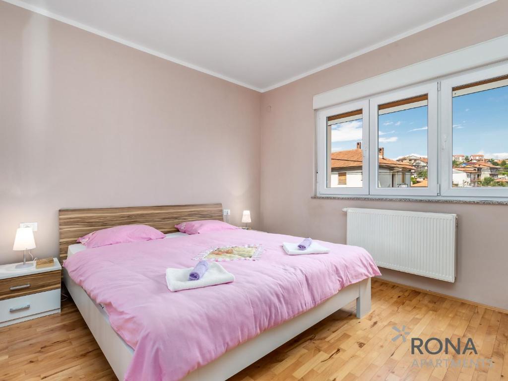 里耶卡Rona apartments Smokva的一间卧室配有一张带粉红色床单的大床