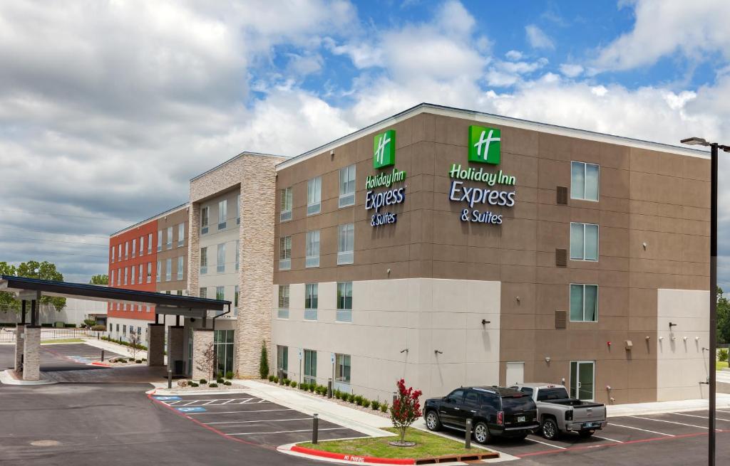塔尔萨Holiday Inn Express & Suites Tulsa South - Woodland Hills, an IHG Hotel的停泊在停车场的卡车的酒店大楼