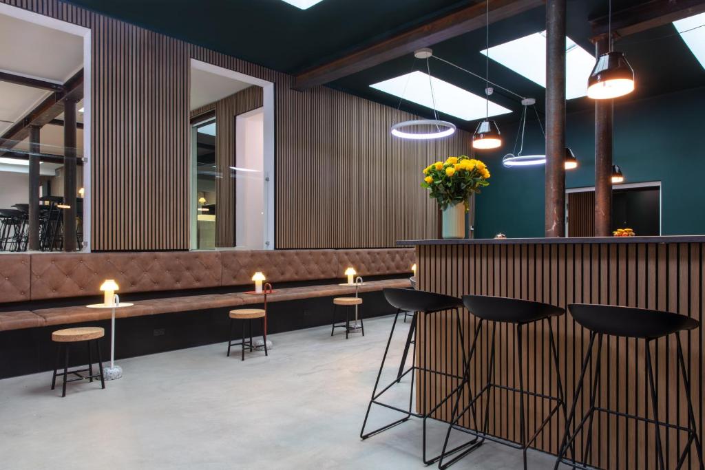 哥本哈根司丽普旅舍的餐厅设有酒吧,配有凳子和灯