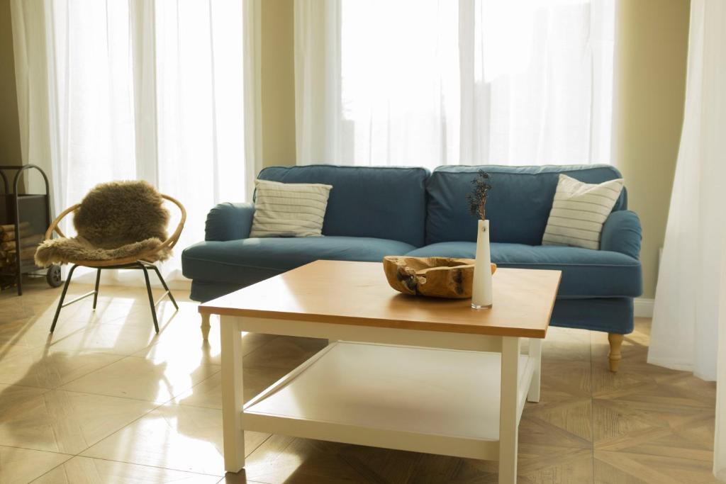 吕贝克Lot Lodge Travemünde的客厅配有蓝色的沙发和桌子