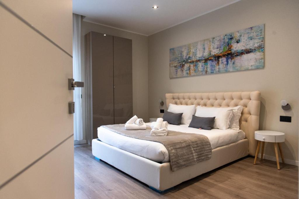 罗马XXIV Domus Luxury Suites的卧室配有一张白色床,墙上挂有绘画作品