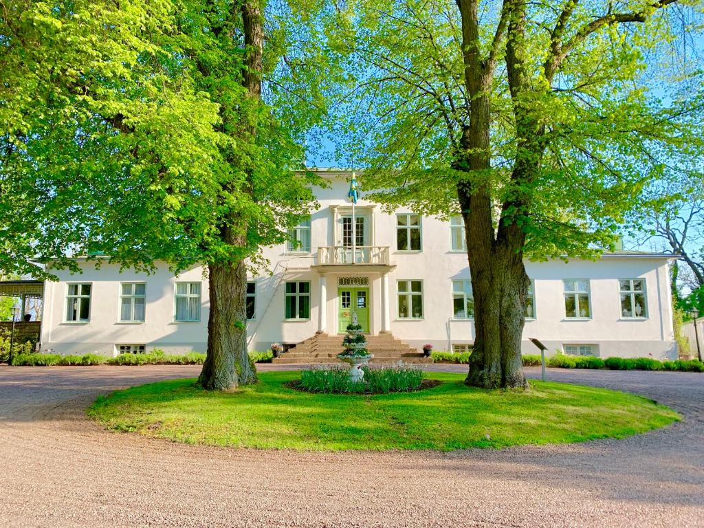 博里霍尔姆多特宁维多利亚酒店与疗养院的前面有树木的白色房子