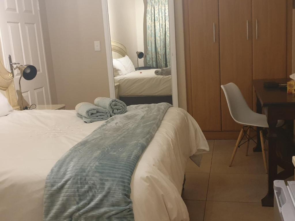 比勒陀利亚Langa's Gabedi Goshen的一间卧室配有一张床、一张书桌和一面镜子