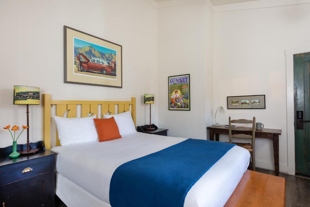 索诺玛索诺玛克里克客栈的卧室配有蓝色和白色的床和书桌。