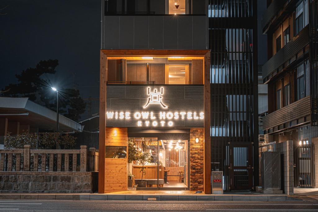 京都Wise Owl Hostels Kyoto的一座建筑物,上面有标志,上面写着妻子向酒店读书