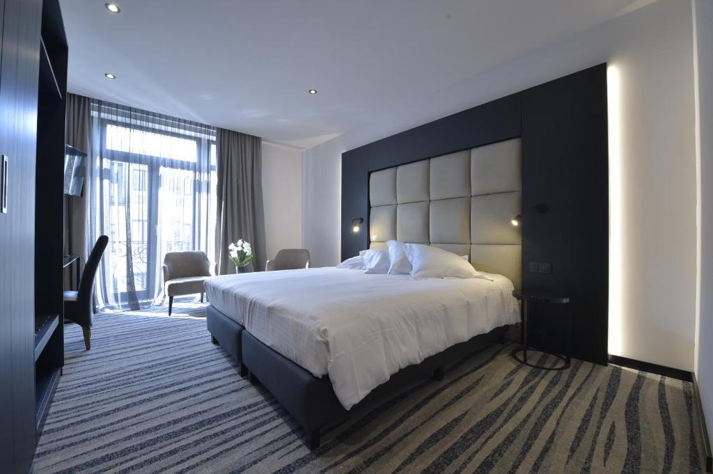 奥斯坦德Hotel Monarc的一间卧室配有一张大床和大床头板