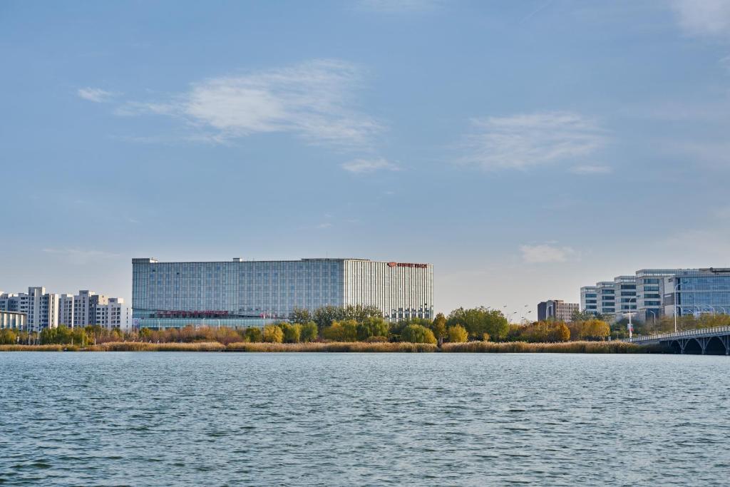 天津天津滨海圣光皇冠假日酒店的一大片水体,有建筑背景