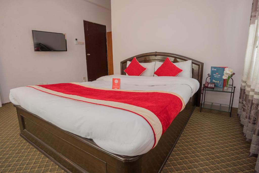 加德满都135迷失花园公寓OYO房山林小屋的一间卧室配有一张带红色枕头的大床
