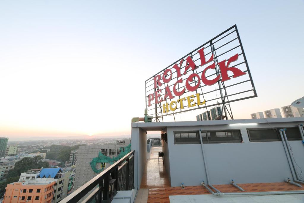 曼德勒Royal Peacock Hotel的大楼顶部带有标志的阳台