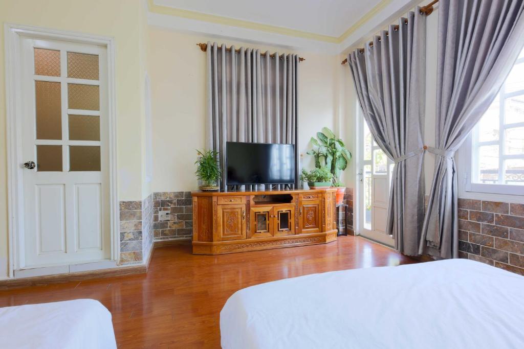 大叻The One Home Đà Lạt的一间带电视、木架和陶瓷器的卧室