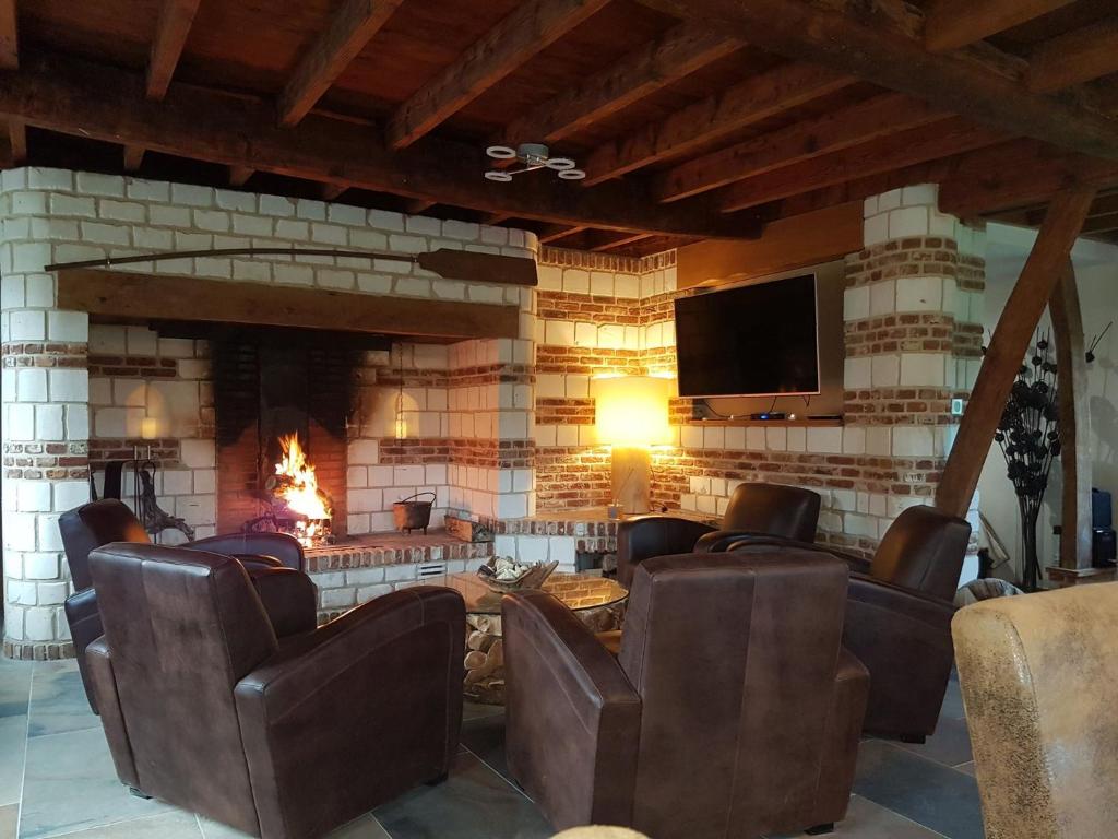 WailLe Domaine de Wail - Legends Resort的客房设有带椅子的壁炉和电视。