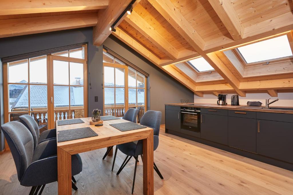 克伦Landhaus Herzogsteig的厨房配有木桌、椅子和窗户。