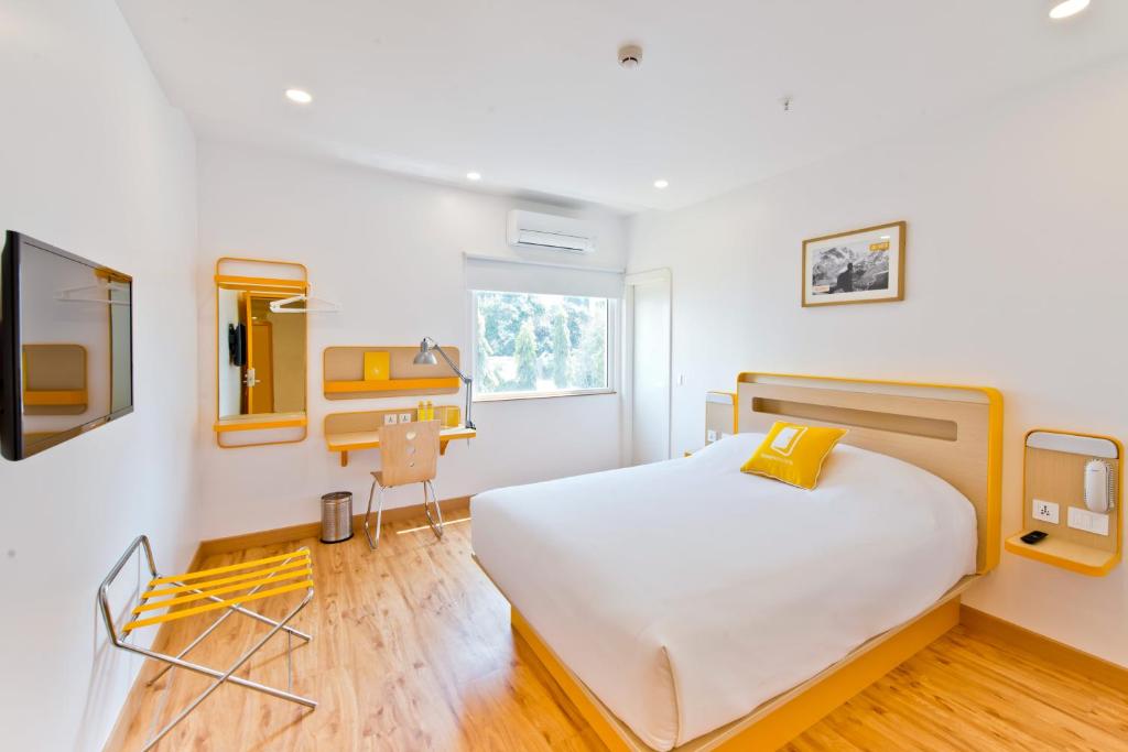 班加罗尔bloomrooms @ City Centre的卧室配有白色的床和书桌