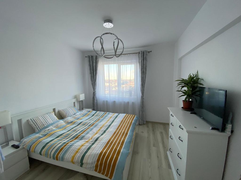 BragadiruLibertatii 88 Luxury Apartment的一间卧室配有一张床、一台电视和一个梳妆台