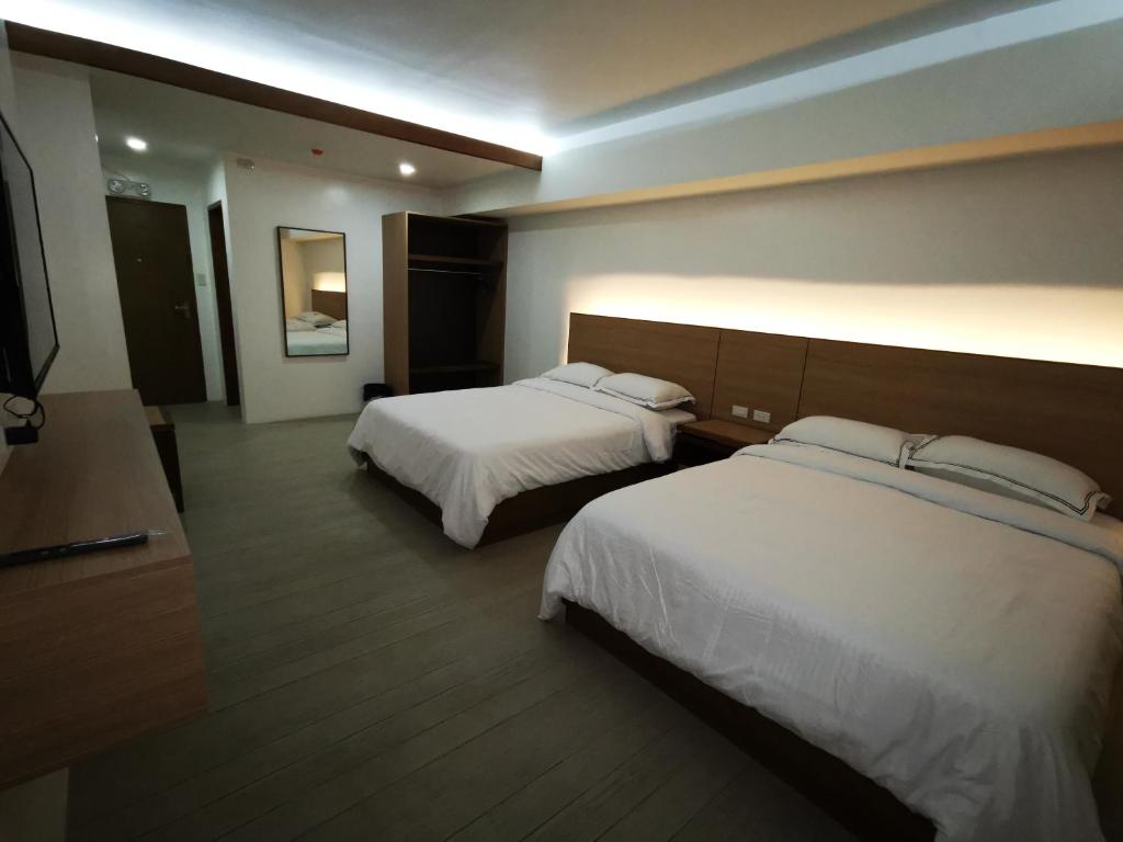 碧瑶Soleo Inn的酒店客房设有两张床和电视。