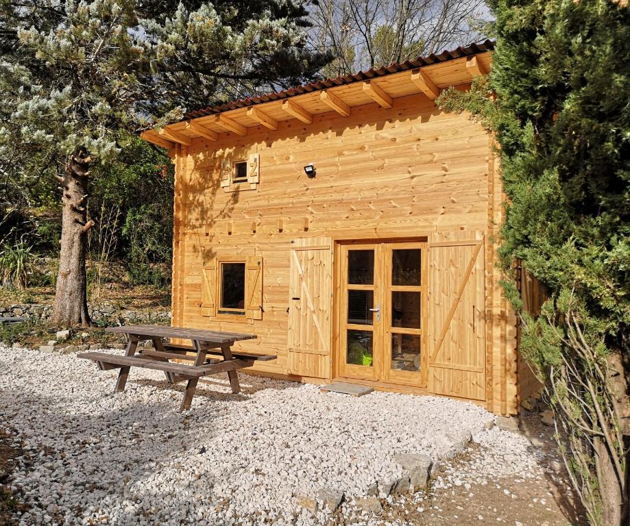 TourvesLa cabane des Pachous的小木屋设有野餐桌和长凳