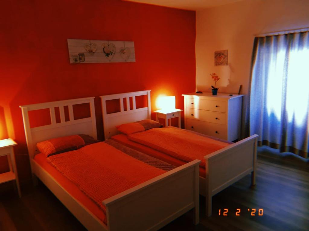加维科利亚诺Ca da la nona的一间卧室设有两张床、一个梳妆台和窗户。