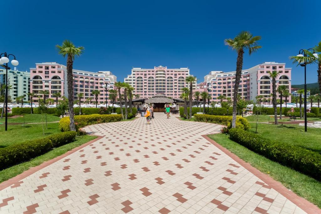 阳光海滩DIT Majestic Beach Resort - Ultra All Inclusive的棕榈树公园和建筑中的步行道