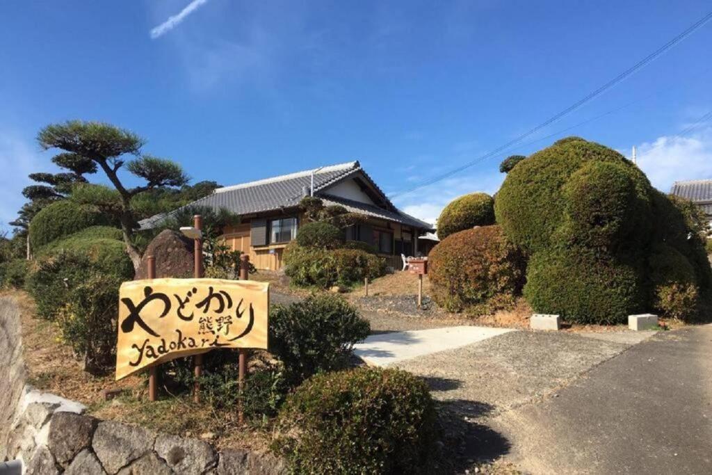 熊野市Yadokari Kumano的院子前有标志的房子