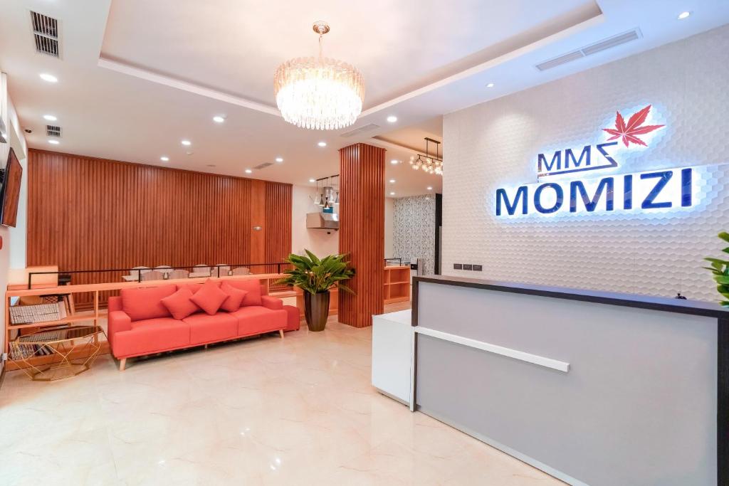 海防MOMIZI Hotel HAI PHONG的大堂设有红色的沙发和标志