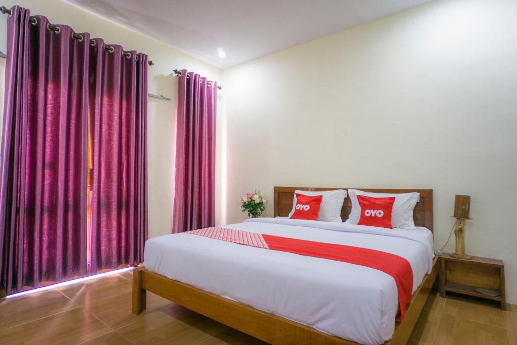 不拉士打宜OYO 1696 Sapo Rumbia的一间卧室配有一张带红色枕头的大床